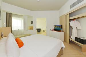 雅加达雅加达太贝特哈里斯酒店的一间白色床和一套沙哑西装的卧室