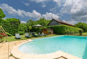 特雷莫拉The cottage at Les Chouettes Tremolat的庭院内的游泳池配有椅子和遮阳伞