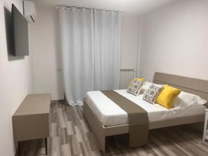 那不勒斯City Home 77的一间卧室配有一张带黄色枕头的床和电视。