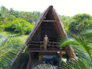 卡尔皮蒂耶Elements Beach & Nature Resort的站在茅草屋顶的女人