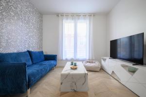 尼斯Le Walesa, magnifique 3P, spacieux et rénové, Port de Nice的客厅配有蓝色的沙发和电视