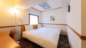 太田市Toyoko Inn Gumma Ota eki Minami guchi的一间小卧室,配有白色的床和窗户