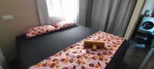 波拉波拉Bora Temahana的一张带粉红色棉被的床,上面有钱包