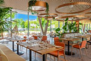 希欧福克REED Luxury Hotel by Balaton的餐厅设有桌椅和大窗户。
