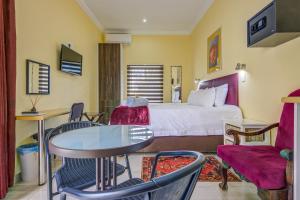 伊登维尔Edenvale Guest House的酒店客房带一张床、一张桌子和椅子