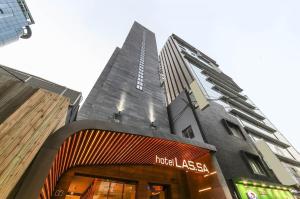首尔Hotel Lassa的前面有酒店拉泽拉标志的高楼
