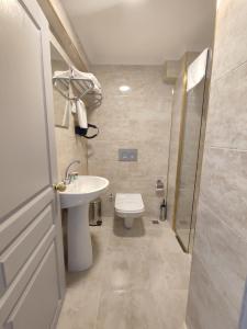 BilecikGRAND KENT OTEL的浴室配有卫生间、盥洗盆和淋浴。