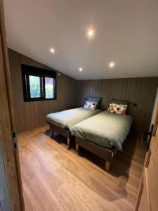 Saint-Sauveur-lès-BrayChalet moderne au bord d'un lac的一间铺有木地板的客房内配有两张床的卧室