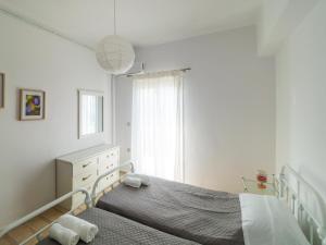 卡沃斯Andronikos Guest House的白色的卧室设有床和窗户