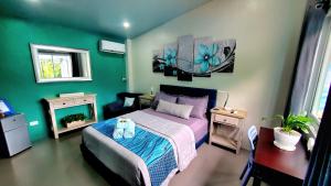 san juan la unionHidden Palms Inn的一间卧室设有一张床和绿色的墙壁