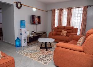 纳库鲁Havan Furnished Apartments- Hyrax Hill的客厅配有两张沙发和一张桌子