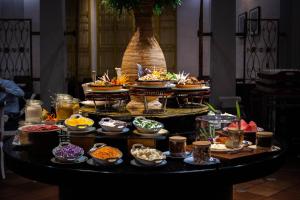 马六甲Grand Swiss-Belhotel Melaka - formerly LaCrista Hotel Melaka的餐桌上的自助餐,包括一碗食物