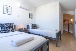 拉纳卡Chloris 3- Bedroom Apartment W/Pool in Larnaca的白色墙壁客房的两张床
