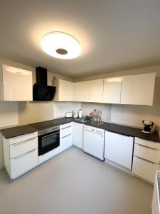 巴特恩豪森Moderne FeWo in HDZ&Klinik Nähe的厨房配有白色橱柜和黑色台面