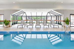 罗切斯特罗彻斯特布赖顿万怡酒店的一座带椅子和桌子的酒店游泳池