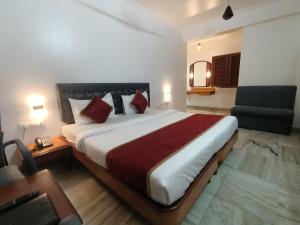 卡延Raja Hotel的酒店客房带一张大床和一把椅子