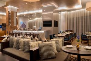 布法罗Buffalo Marriott at LECOM HARBORCENTER的一间带沙发和桌子的餐厅和一间酒吧