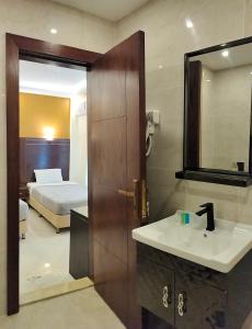 瓦迪穆萨Petra Town Check-Inn的一间带水槽和镜子的浴室以及一张床