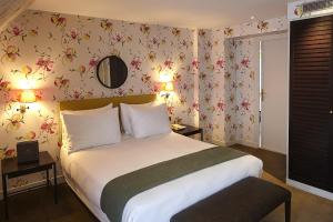 巴黎多瑙河圣日耳曼酒店的一间卧室配有一张带花卉壁纸的大床