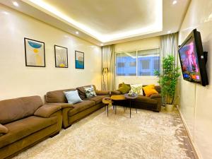 卡萨布兰卡Cosy and greeny flat near oasis train and tramway的带沙发和电视的客厅