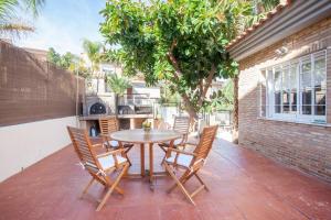 瓦伦西亚Casa en Valencia, cerca de golf, playas, moto Gp的天井上种有树,配有桌椅
