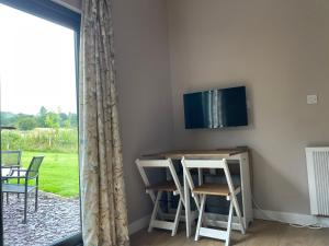 West BradfordBeautiful self-catering cottages, Ribble Valley的一间设有桌椅的房间和墙上的电视