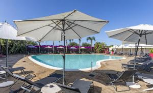锡拉库扎信天翁酒店的一个带椅子和遮阳伞的游泳池