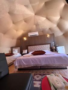 瓦迪拉姆Bubble camp 2的一间卧室设有一张带木制天花板的大床