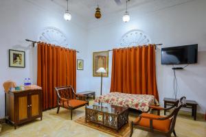瓜廖尔尼姆拉纳斯 - 迪奥巴格酒店的一间卧室配有橙色窗帘、一张床和电视