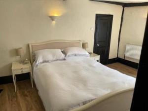 埃平SmithStayz Apartments Epping的一张带白色床单和枕头的床