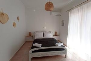 扎金索斯镇Bougainvillea apartment的一间白色卧室,卧室内配有一张床