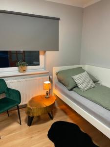 Nowy WiśniczSzmaragdowy domek的一间卧室配有一张床、一把椅子和一张桌子