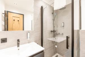 萨尔巴赫Saalbach Suites by ALPS RESORTS的带淋浴、盥洗盆和镜子的浴室