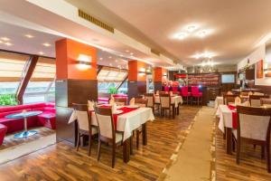 什特尔巴Hotel Sipox的一间带桌椅和红色座椅的餐厅