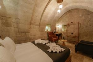 格雷梅Göreme Escape Cave Suites的一间卧室配有一张大床和毛巾