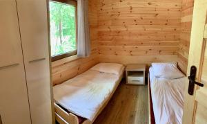 BorzechowoOśrodek Wypoczynkowy Jeziornik的小房间设有两张床和窗户