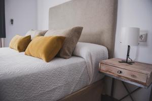 埃希哈Apartamento La Milagrosa的一间卧室配有一张带枕头和桌子的床