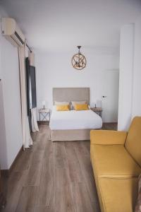 埃希哈Apartamento La Milagrosa的白色卧室配有床和沙发