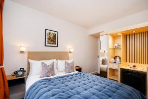 布里斯托The Rodney Hotel的一间卧室配有蓝色的床和一张书桌
