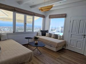 费拉Amerisa Suites & Villa的一间卧室设有两张床和一张带窗户的沙发。
