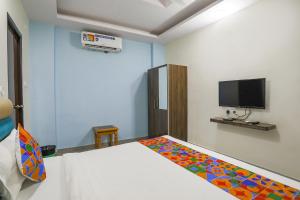 ChinhatFabHotel SM Palace的卧室配有一张床,墙上配有电视。
