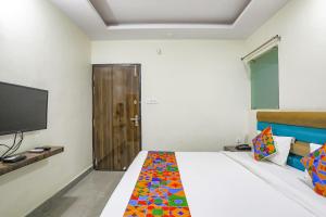 ChinhatFabHotel SM Palace的一间卧室配有一张带电视的床和一张四柱床。