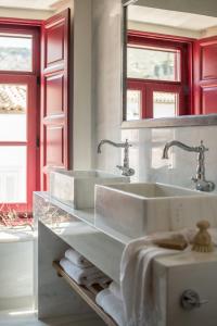 伊兹拉FOS Hydra residence的白色浴室设有两个盥洗盆和红色窗户