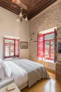伊兹拉FOS Hydra residence的一间卧室设有一张大床和红色窗户。