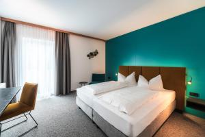 蒙德塞Landhotel Prielbauer的一间卧室设有一张大床和蓝色的墙壁