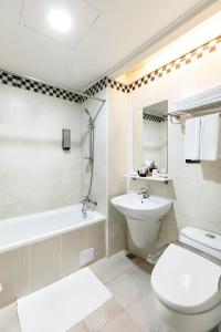 台北多郎明哥商务旅馆的浴室配有卫生间、盥洗盆和浴缸。