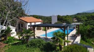 塞尔察Villa Adriana的一座带游泳池和蓝色遮阳篷的别墅