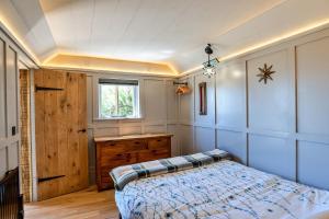 PoundstockFinest Retreats - Driftwood的一间卧室配有一张床、一个梳妆台和一扇窗户。