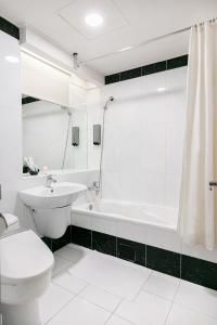 台北多郎明哥商务旅馆的白色的浴室设有卫生间、水槽和浴缸。