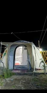 GulmitBaseet Camping and Restaurant的夜晚坐在田野里的帐篷